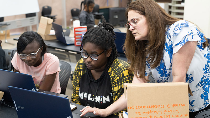 Photo of a female teacher with two students